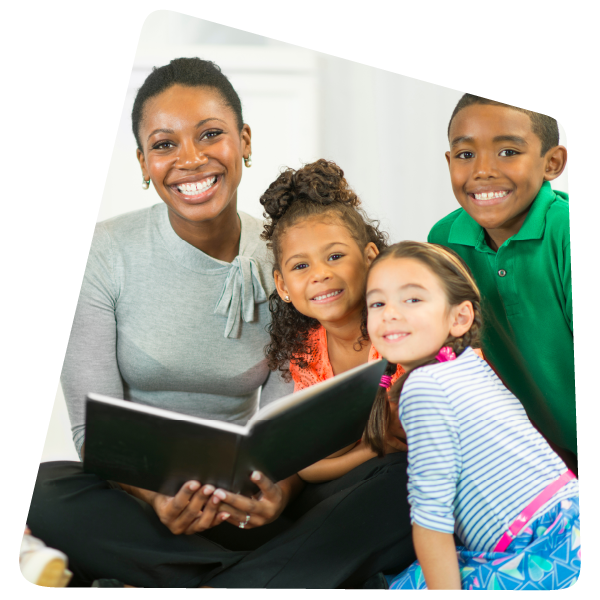 Teacher holding book, smiling with students Teacher holding book, smiling with students
