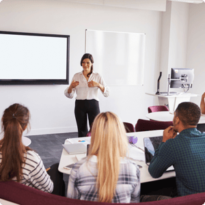 CLASS Trainer at front of lecture room, training several students with their backs to camera.