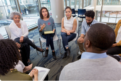 Leaders sitting on chairs in circle discussing