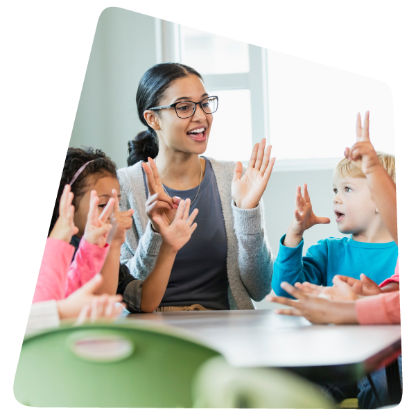 An educator in class, counting at a table with preschool-aged children. An educator in class, counting at a table with preschool-aged children.