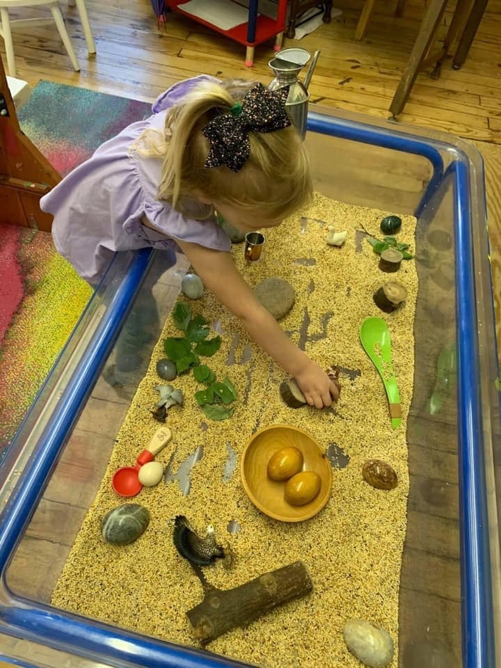 Sensory table filled with rice and toys